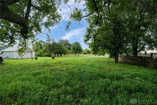 view of yard featuring an outbuilding, an outdoor structure, and fence