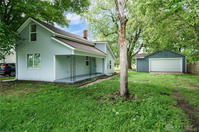 exterior space with an outbuilding, a lawn, a chimney, and a garage