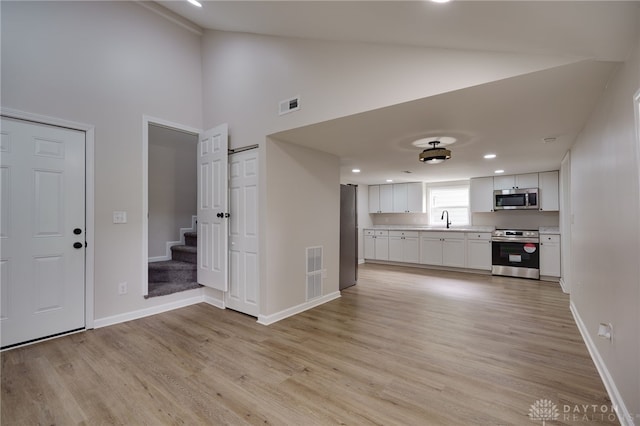 interior space with visible vents, a sink, light countertops, appliances with stainless steel finishes, and white cabinetry