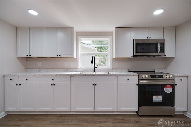 kitchen featuring a sink, stainless steel appliances, light countertops, and white cabinetry