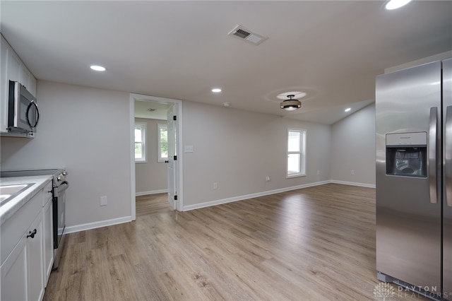 kitchen featuring visible vents, baseboards, white cabinets, light wood-style floors, and appliances with stainless steel finishes