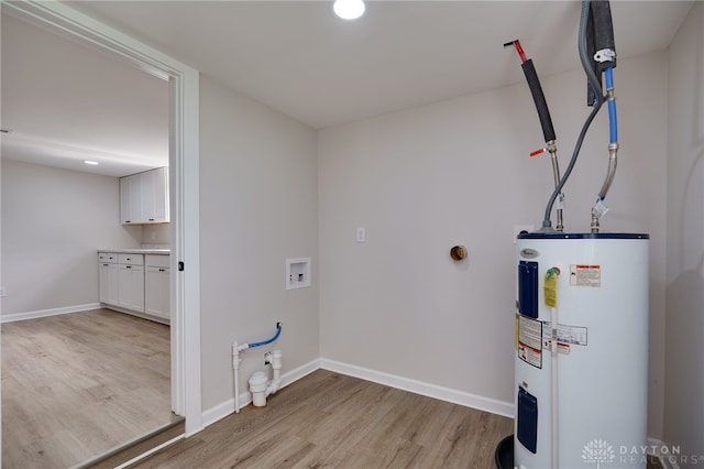 laundry room featuring baseboards, laundry area, light wood-style flooring, water heater, and washer hookup