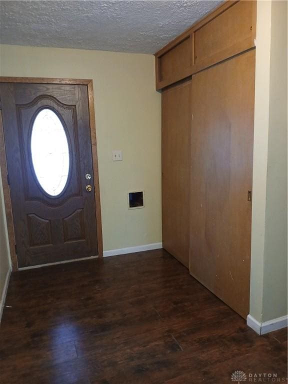 entrance foyer with dark hardwood / wood-style flooring and a textured ceiling