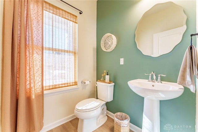 bathroom with a healthy amount of sunlight, hardwood / wood-style floors, and toilet