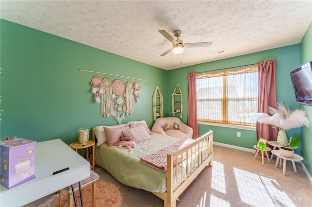 carpeted bedroom with ceiling fan and a textured ceiling