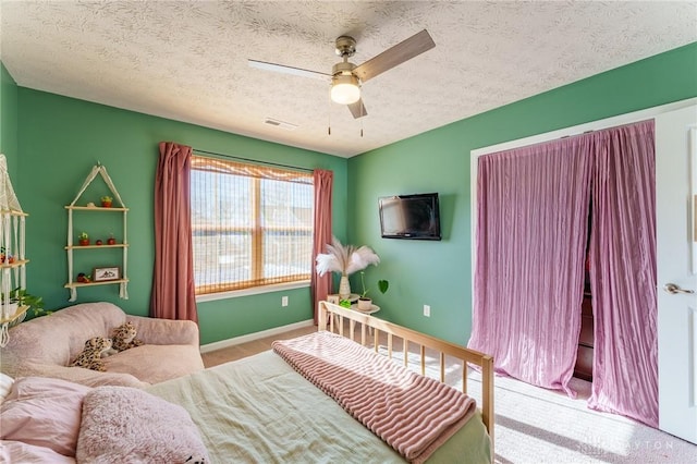 carpeted bedroom with ceiling fan and a textured ceiling