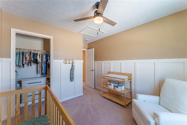 bedroom featuring light carpet, a textured ceiling, a closet, and ceiling fan