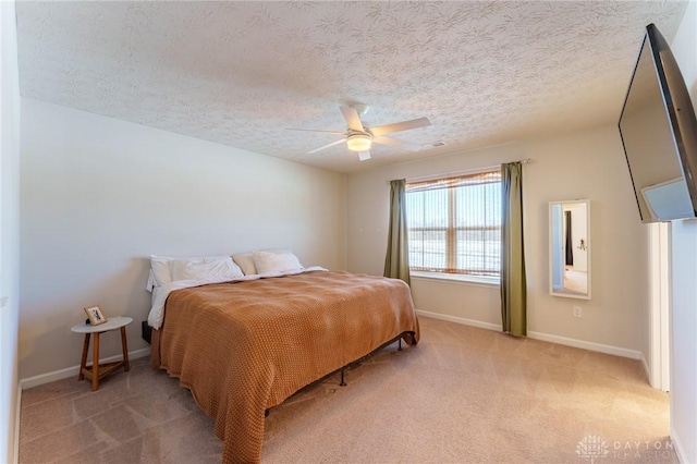 bedroom with light colored carpet, a textured ceiling, and ceiling fan