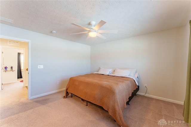 bedroom with light colored carpet, a textured ceiling, and ceiling fan