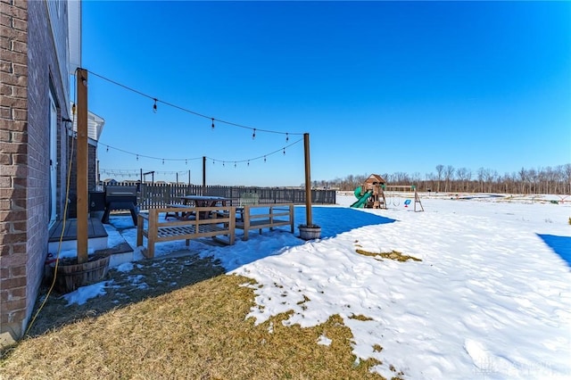 yard layered in snow with a playground