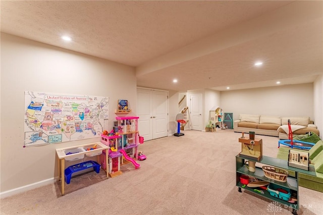 rec room featuring carpet floors and a textured ceiling