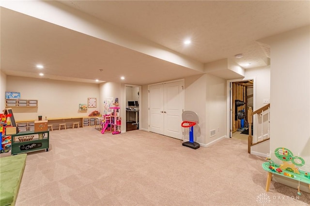 recreation room featuring light carpet