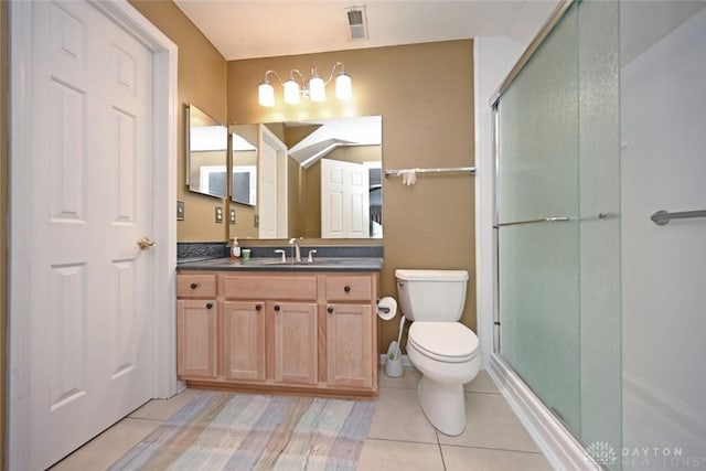 bathroom with tile patterned flooring, vanity, a shower with door, and toilet