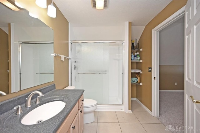 bathroom with tile patterned flooring, vanity, a shower with door, and toilet