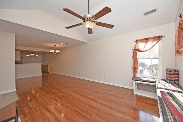 unfurnished living room with hardwood / wood-style flooring, vaulted ceiling, and ceiling fan with notable chandelier