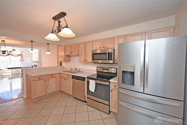 kitchen featuring light brown cabinetry, sink, light tile patterned floors, appliances with stainless steel finishes, and pendant lighting