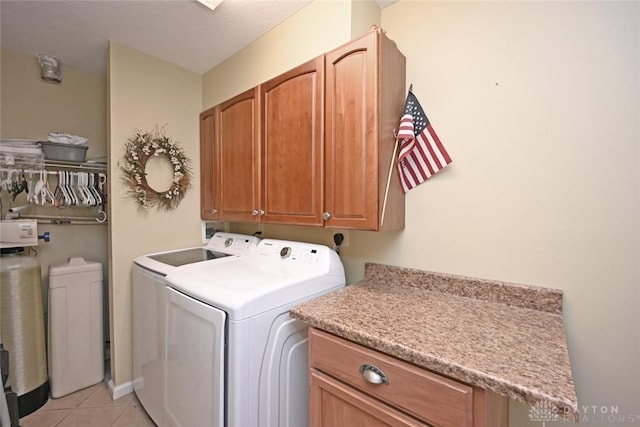 laundry area with light tile patterned flooring, cabinets, and washer and dryer