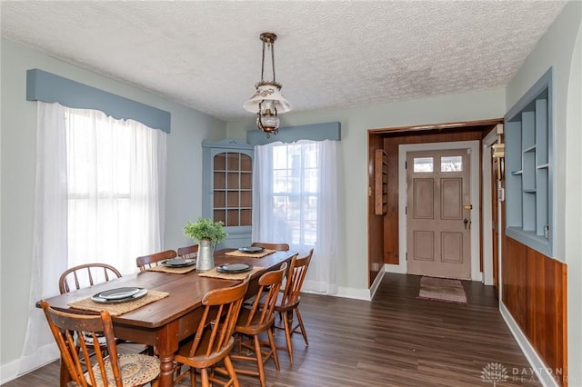 dining space with dark hardwood / wood-style flooring and a textured ceiling