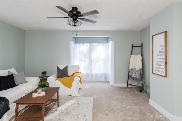 carpeted living room with a textured ceiling and ceiling fan