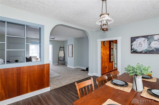 dining room featuring wood-type flooring and a textured ceiling