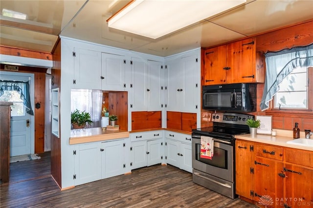 kitchen featuring dark hardwood / wood-style floors, stainless steel electric stove, sink, and white cabinets