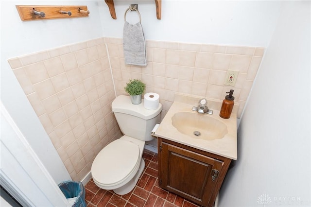 bathroom with vanity, toilet, tile patterned flooring, and tile walls