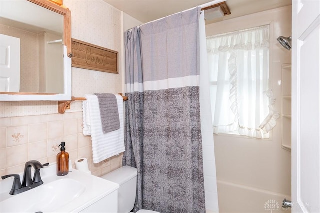 bathroom featuring sink, backsplash, and toilet