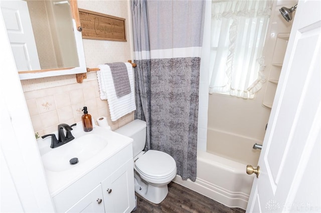 full bathroom with shower / tub combo with curtain, toilet, vanity, hardwood / wood-style flooring, and backsplash