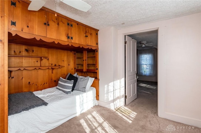 carpeted bedroom with a textured ceiling and ceiling fan