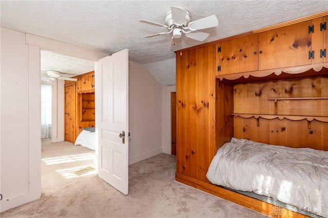 unfurnished bedroom with light carpet, a textured ceiling, ceiling fan, and wood walls