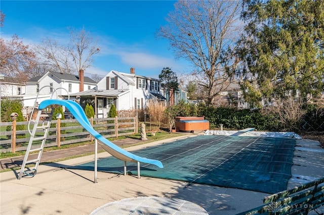 view of playground with a hot tub and a patio