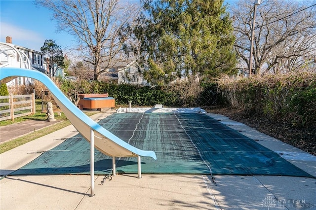 view of pool featuring a hot tub and a water slide