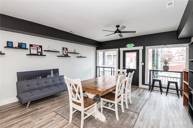 dining space with hardwood / wood-style flooring and ceiling fan