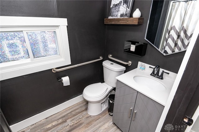 bathroom with hardwood / wood-style flooring, vanity, and toilet