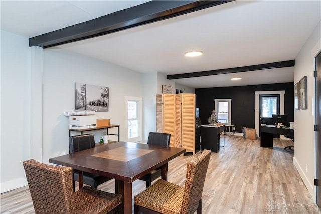 dining space featuring beamed ceiling and light hardwood / wood-style floors