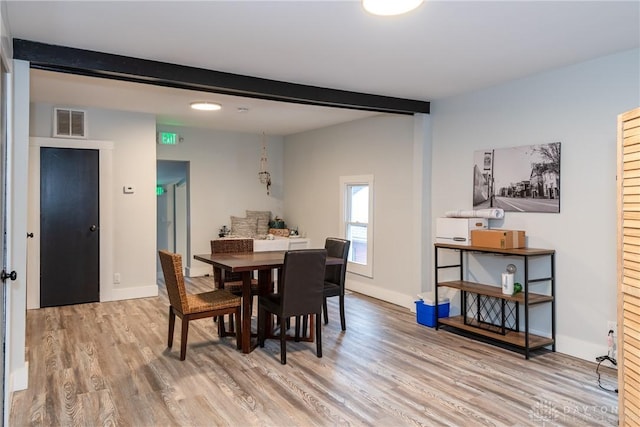 dining area with wood-type flooring and beam ceiling