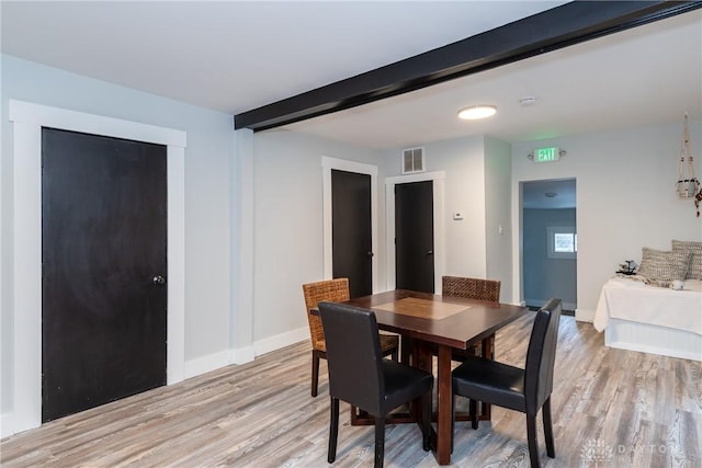 dining area with beam ceiling and light hardwood / wood-style flooring