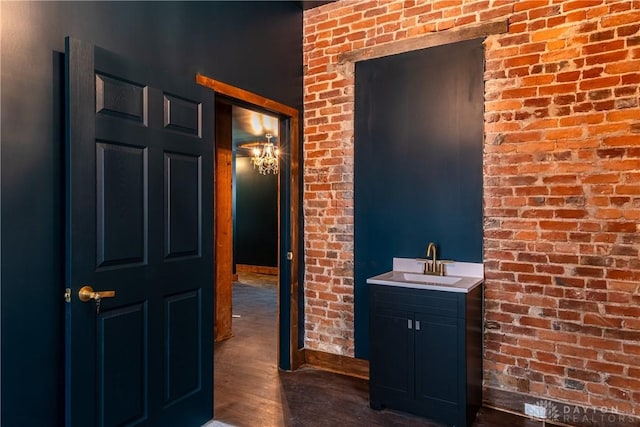 bathroom featuring vanity, brick wall, and wood-type flooring