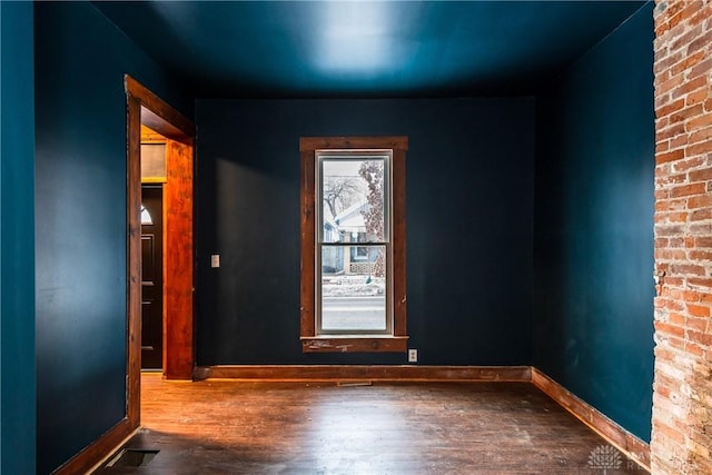 empty room with plenty of natural light and hardwood / wood-style floors