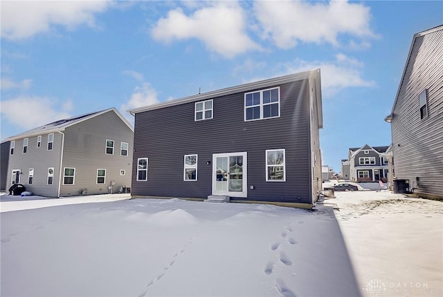 snow covered rear of property with central air condition unit