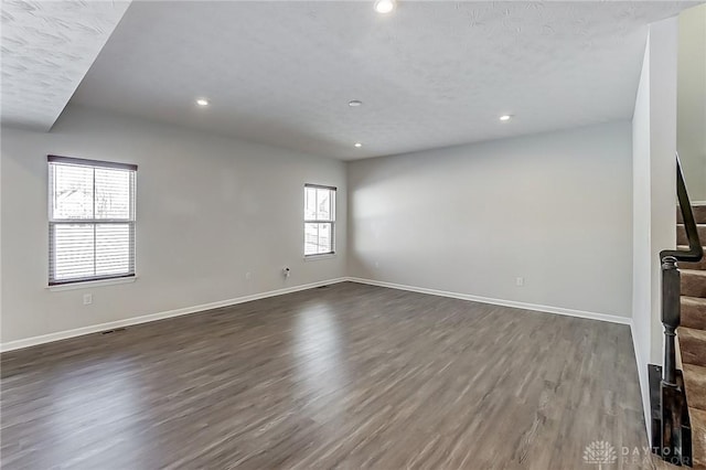 unfurnished living room with dark wood-type flooring and plenty of natural light