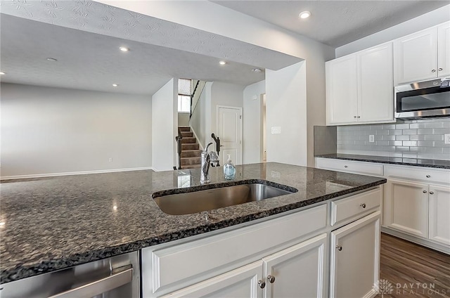 kitchen featuring white cabinetry, sink, decorative backsplash, dark stone counters, and stainless steel appliances