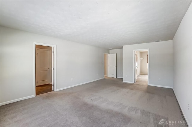 carpeted spare room with a textured ceiling