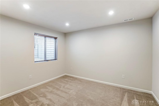 spare room featuring light colored carpet