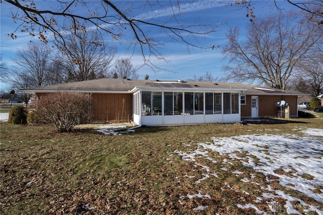 snow covered property with a sunroom and a yard