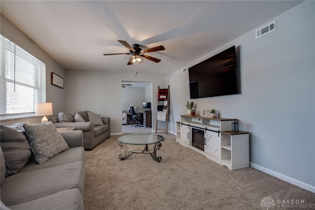 living room with ceiling fan, light carpet, and a fireplace