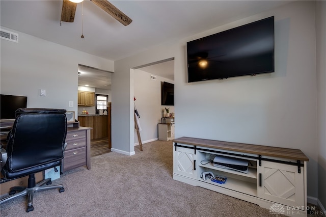 carpeted home office featuring ceiling fan