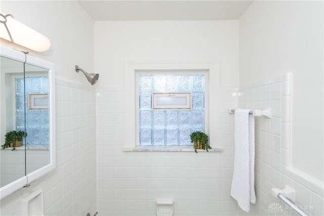 bathroom with a shower and tile walls