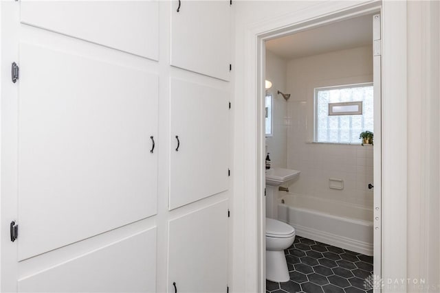 bathroom with tiled shower / bath and toilet