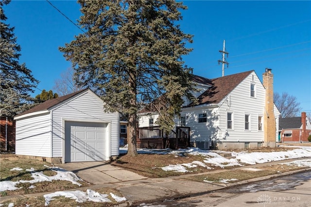 view of front of house featuring a garage, central AC unit, an outdoor structure, and a deck